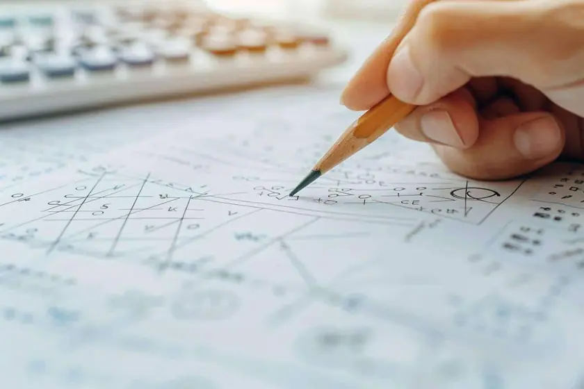 Cahier à grands carreaux montrant une division posée sous la potence avec le reste entouré au crayon