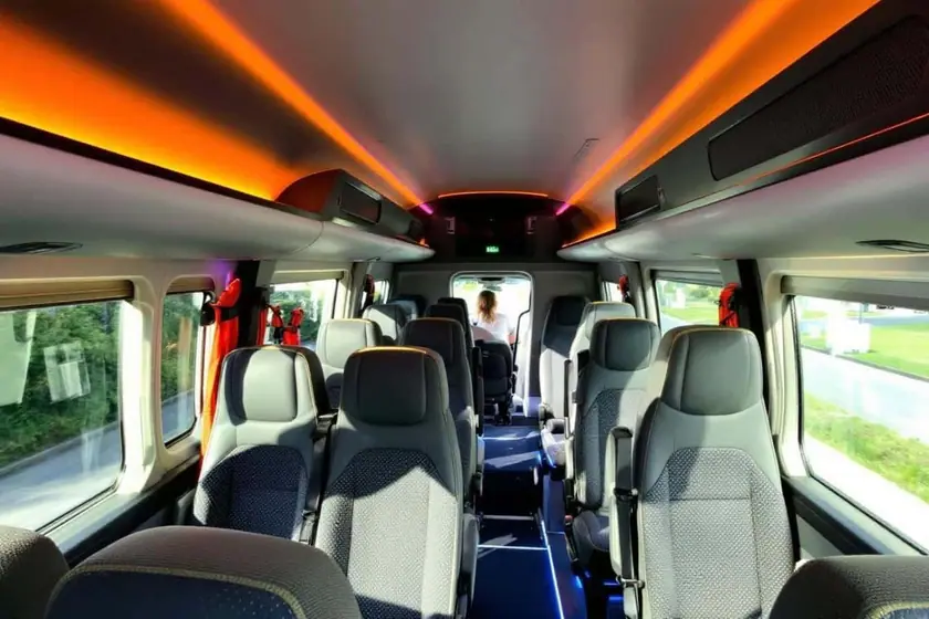 Minibus de location stationné avec porte latérale ouverte sur un intérieur climatisé