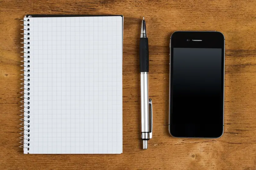 Stylos publicitaires alignés sur un bureau, dont un marqué d'un logo monochrome